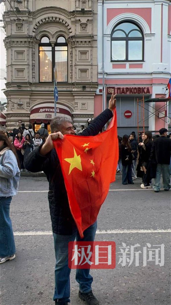 涵星配资 俄罗斯大学教师在阅兵彩排现场展示中国国旗，莫斯科小哥骄傲地称“那是我爸爸！”